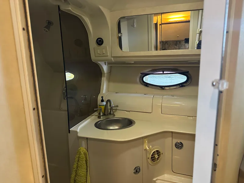 Slide: The Image of 1997 Regal Commodore 402 yacht bathroom with sink, mirror, and porthole window. - 34