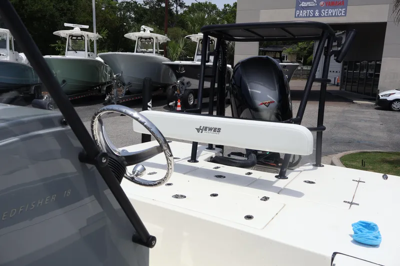 Slide: The Image of 2025 Hewes Redfisher 18 boat console with steering wheel and controls. - 7