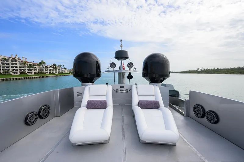 Slide: The Image of Luxurious 2009 Pershing 90 Express yacht deck with white loungers and scenic water view. - 44