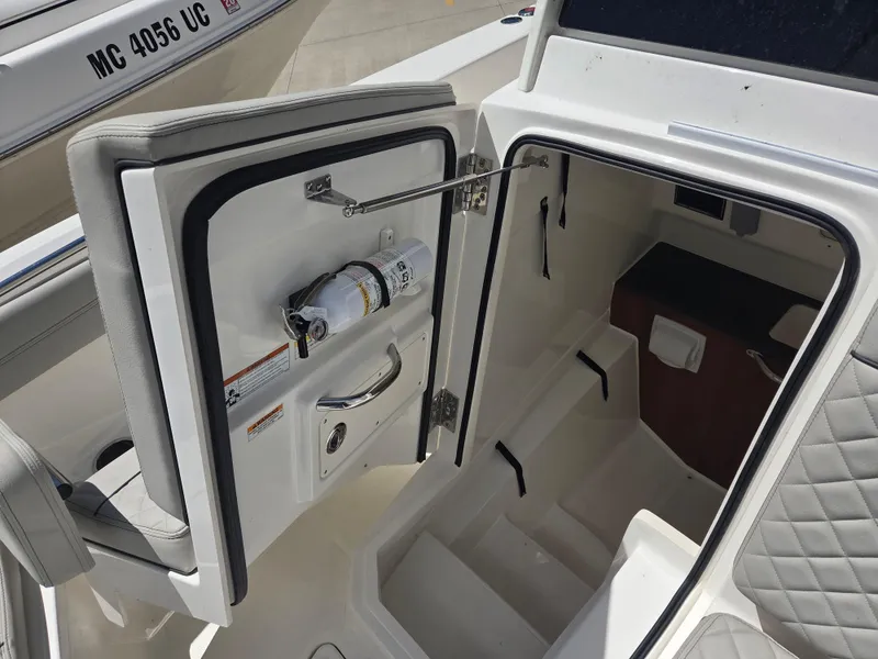 Slide: The Image of 2025 Pursuit S 288 Sport boat interior with open cabin door, showcasing seating and storage. - 24