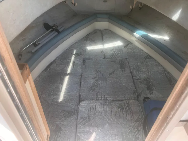 Slide: The Image of 1992 Grady-White 22 Seafarer cabin interior with cushioned seating and fishing rod storage. - 23