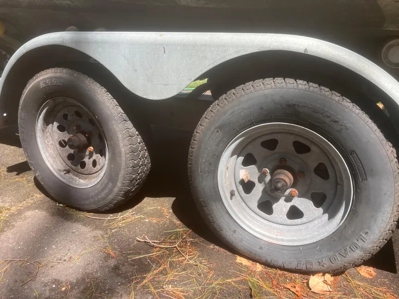 Slide: The Image of Trailer wheels of a 1992 Grady-White 22 Seafarer boat, parked on a sunlit surface. - 27