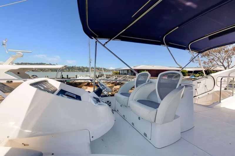 Slide: The Image of 2009 Sunseeker Manhattan 70 yacht helm with seating and canopy, docked in marina. - 13