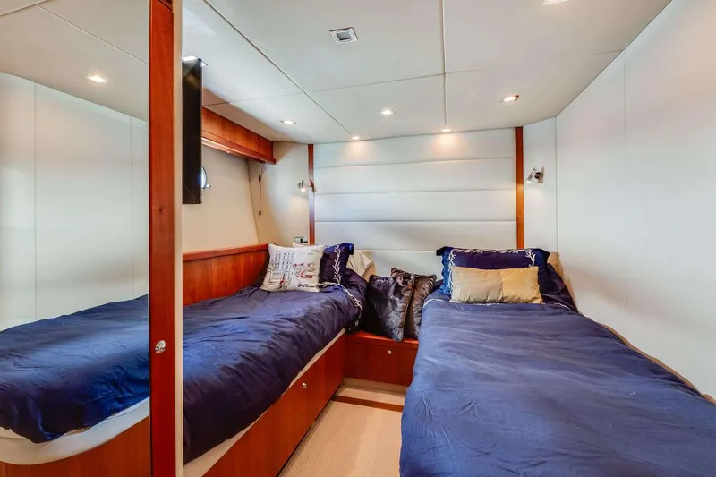 Slide: The Image of Luxurious twin cabin in 2009 Sunseeker Manhattan 70 yacht, featuring elegant bedding and modern lighting. - 17