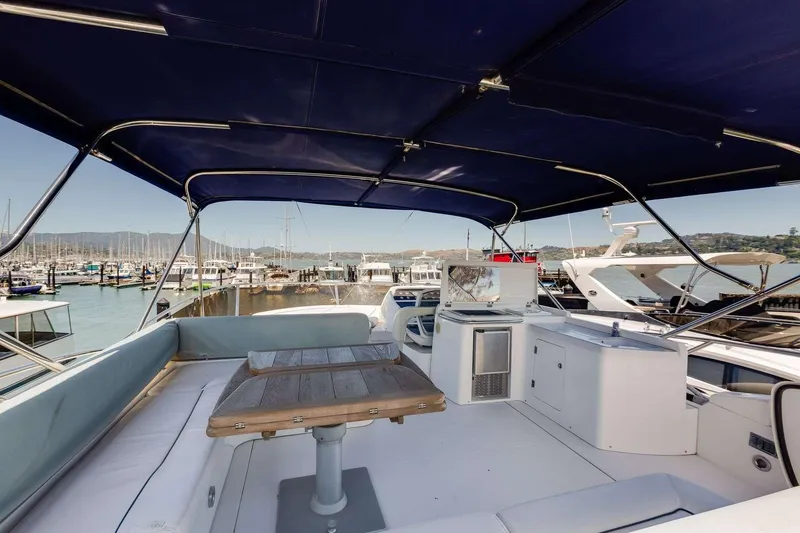 Slide: The Image of 2009 Sunseeker Manhattan 70 yacht interior with seating and table, docked at marina. - 8