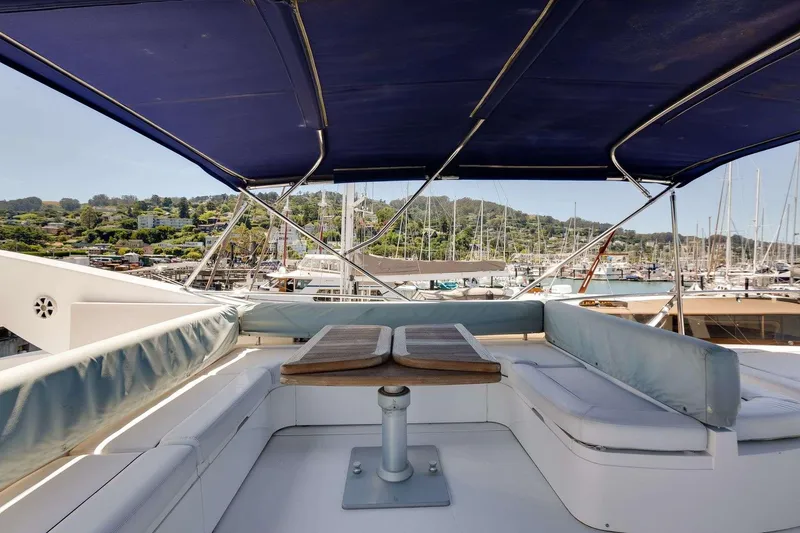 Slide: The Image of Sunseeker Manhattan 70 yacht deck with blue canopy, docked in marina, 2009 model. - 9