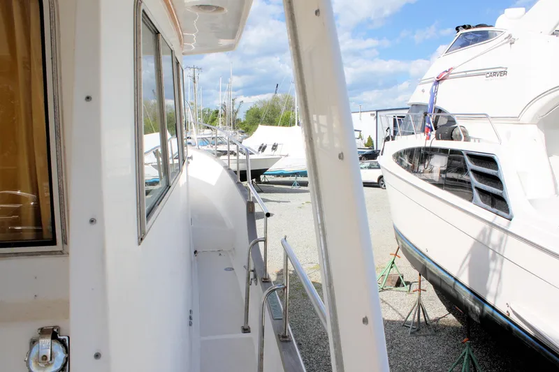 Slide: The Image of Side view of a 2000 Island Gypsy 32 yacht in a marina, surrounded by other boats. - 11