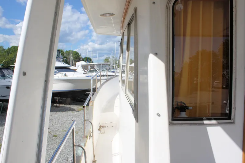Slide: The Image of Island Gypsy 32 yacht side view, docked with clear sky and other boats nearby. - 12