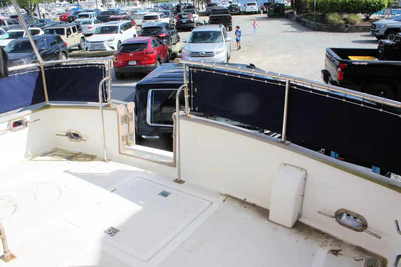 Slide: The Image of Island Gypsy 32 boat deck overlooking parking lot with various cars, 2000 model. - 14