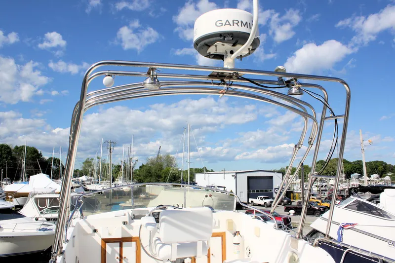 Slide: The Image of Island Gypsy 32 boat, 2000 model, with Garmin radar, docked under a clear blue sky. - 18