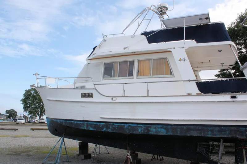 Slide: The Image of Island Gypsy 32 yacht from 2000 on dry dock, side view with blue sky background. - 2