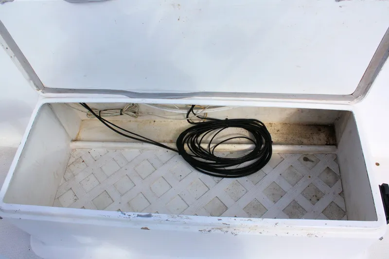 Slide: The Image of Open storage compartment on 2000 Island Gypsy 32 boat with coiled cables inside. - 22
