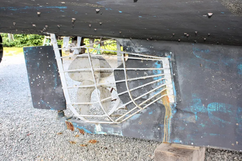 Slide: The Image of Propeller and protective cage of a 2000 Island Gypsy 32 boat on gravel. - 25