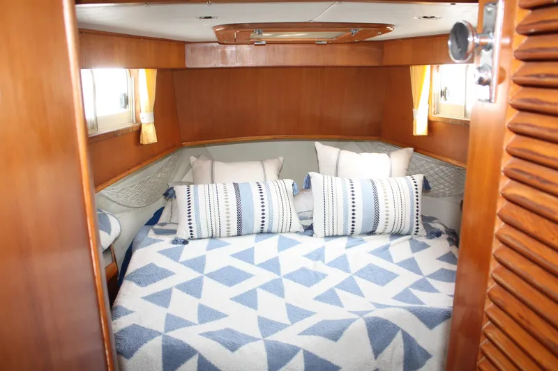 Slide: The Image of Cozy cabin interior of 2000 Island Gypsy 32 with patterned bedding and wooden accents. - 27