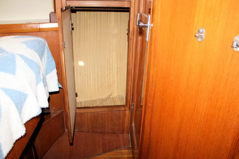 Slide: The Image of Wooden interior of 2000 Island Gypsy 32 boat, featuring an open storage cabinet. - 32