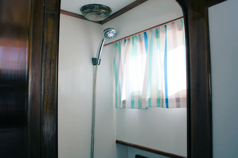 Slide: The Image of Shower area in 2000 Island Gypsy 32 boat with striped curtain and wooden trim. - 35