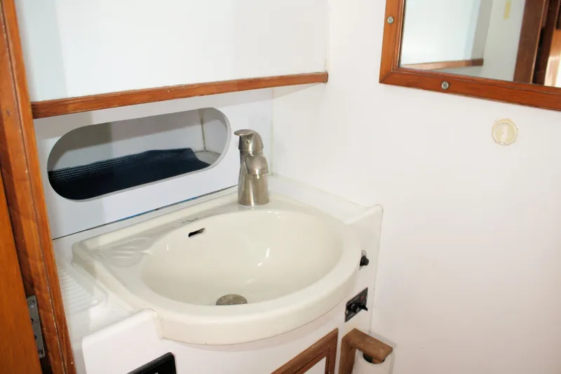 Slide: The Image of Bathroom sink area in a 2000 Island Gypsy 32 boat, featuring a modern faucet. - 37