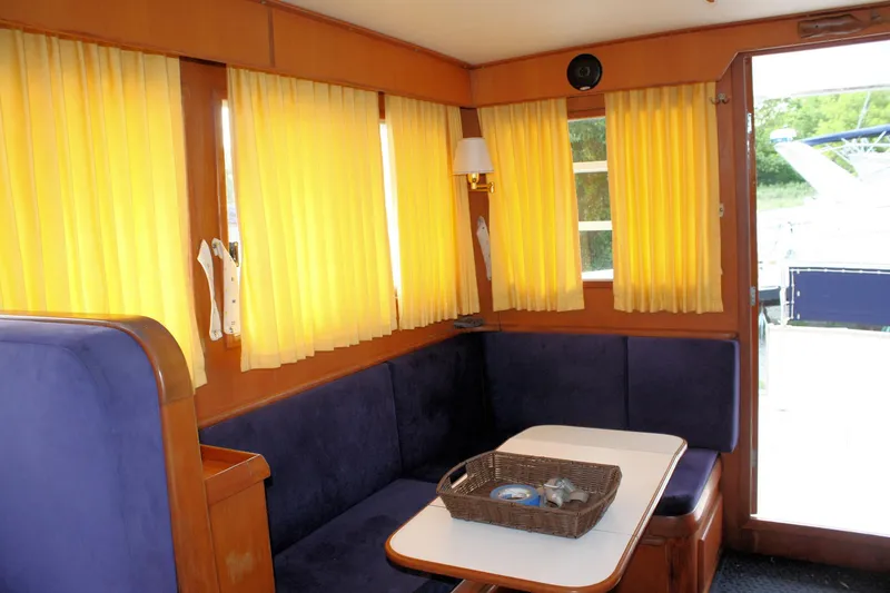 Slide: The Image of Cozy interior of 2000 Island Gypsy 32 yacht with yellow curtains and blue seating. - 39