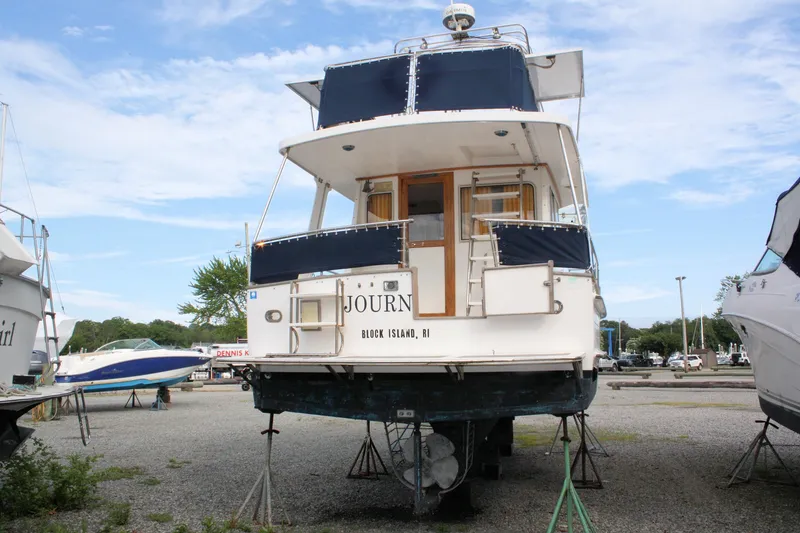 Slide: The Image of Island Gypsy 32 yacht from 2000 on dry dock, rear view, clear sky background. - 4