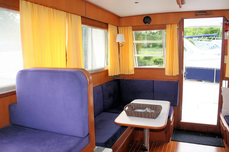 Slide: The Image of Interior of 2000 Island Gypsy 32 boat with blue seating and yellow curtains. - 40