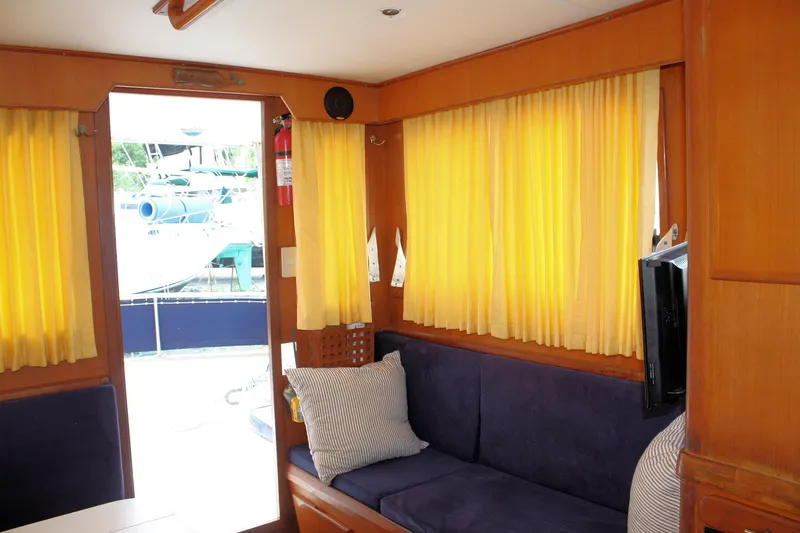Slide: The Image of Interior of 2000 Island Gypsy 32 boat with yellow curtains and blue seating. - 41