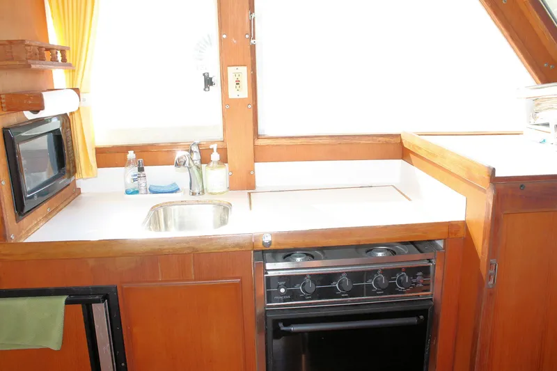 Slide: The Image of Island Gypsy 32 yacht kitchen with stove, sink, and microwave, 2000 model. - 44