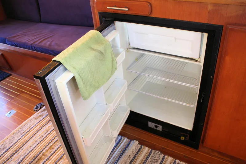 Slide: The Image of Open fridge in Island Gypsy 32 yacht, 2000 model, with a green towel on the door. - 46