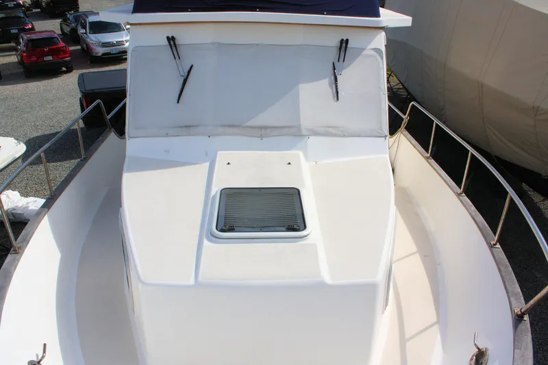 Slide: The Image of Island Gypsy 32 boat deck, 2000 model, with railing and hatch, parked outdoors. - 7