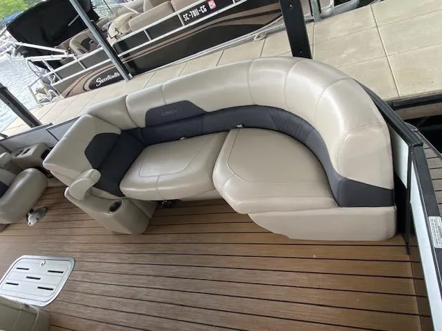 Slide: The Image of 2019 Coach Pontoons 230 RF Tritoon with beige seating on wooden deck. - 6