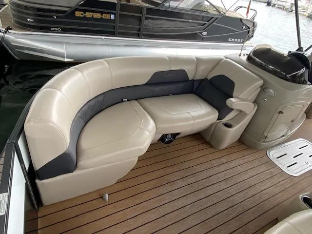 Slide: The Image of 2019 Coach Pontoons 230 RF Tritoon with beige seating and wood deck. - 9