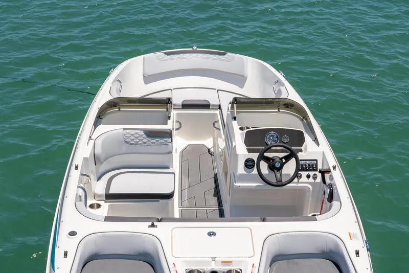 Slide: The Image of 2024 Bayliner M17 boat interior with steering wheel, seating, and dashboard on water. - 13