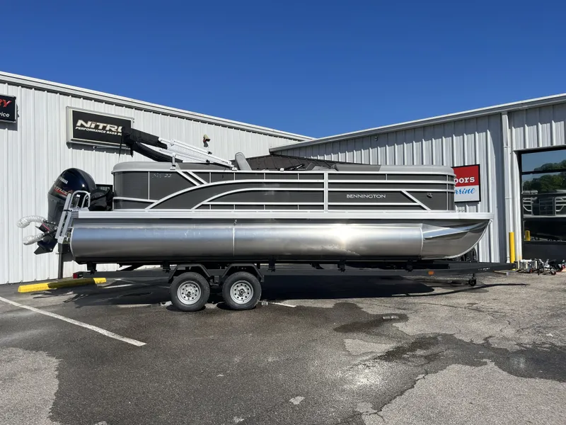 The Image of 2024 Bennington 22 SVSR pontoon boat on trailer, parked outside a building. - 1