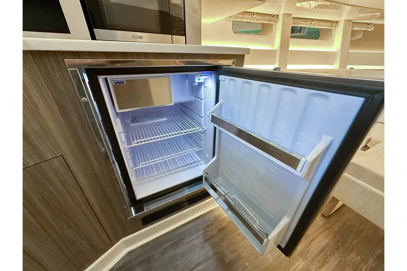 Slide: The Image of Open refrigerator inside 2025 Sea Ray Sundancer 370 yacht, showcasing modern interior design. - 15