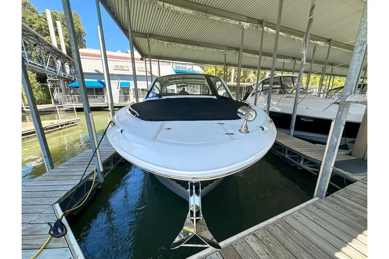 Slide: The Image of 2025 Sea Ray Sundancer 370 docked in a marina under a covered slip. - 2