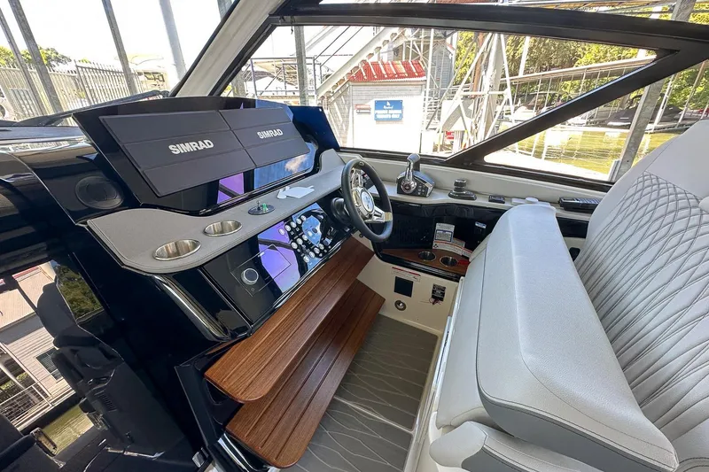 Slide: The Image of 2025 Sea Ray Sundancer 370 helm with Simrad displays and luxurious seating. - 49