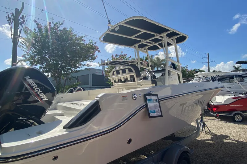 Slide: The Image of 2023 Bayliner Trophy T20CC boat with Mercury engine, displayed outdoors under clear sky. - 10