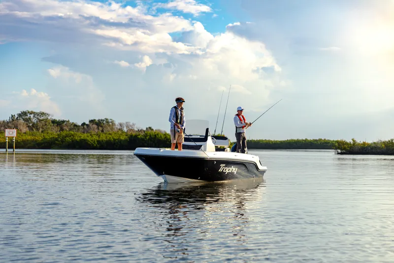 Slide: The Image of 2023 Bayliner Trophy 20CC boat with two people fishing on calm water. - 14