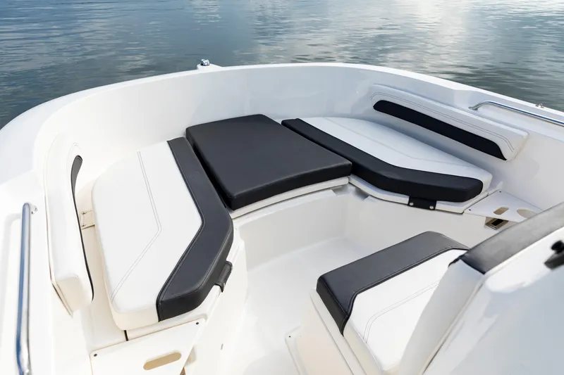 Slide: The Image of 2023 Bayliner Trophy 20CC boat interior with cushioned seating, on calm water. - 21