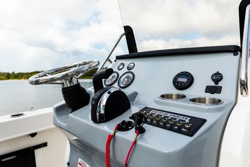 Slide: The Image of 2023 Bayliner Trophy 20CC boat dashboard with steering wheel and controls. - 24