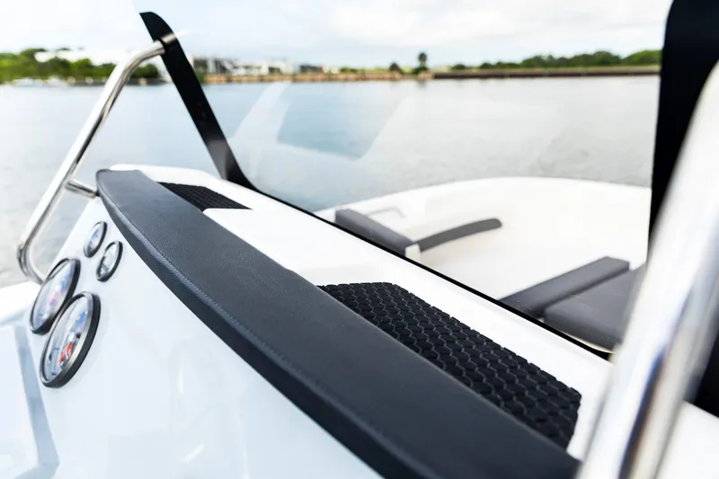Slide: The Image of 2023 Bayliner Trophy 20CC boat interior with dashboard and seating, on calm water. - 30