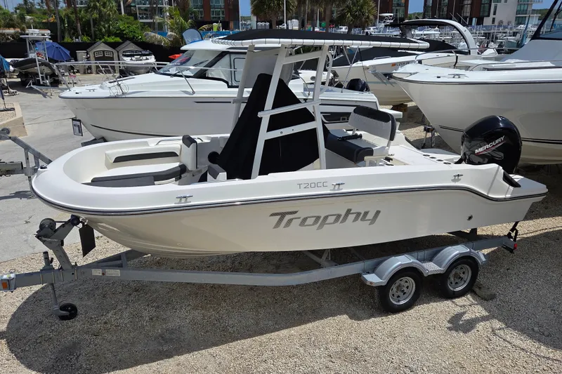 Slide: The Image of 2023 Bayliner Trophy T20CC boat on trailer, displayed at a marina with other boats. - 3