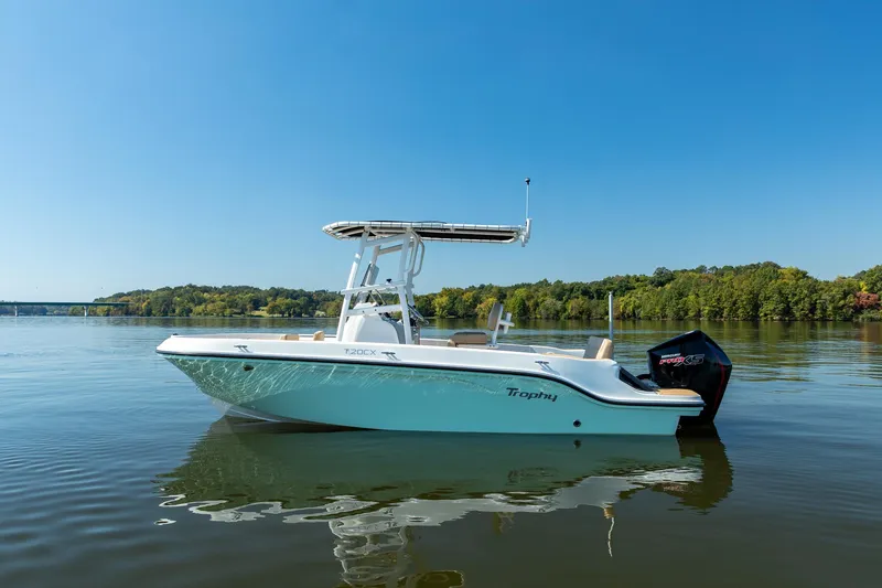 The Image of 2024 Bayliner Trophy 20CX boat on calm lake with clear blue sky. - 0