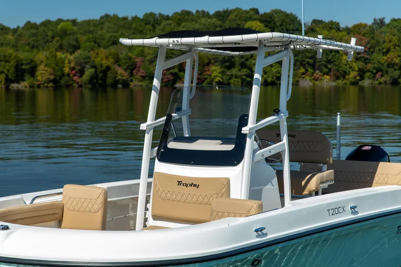 Slide: The Image of 2024 Bayliner Trophy 20CX boat on a calm lake with lush green background. - 10