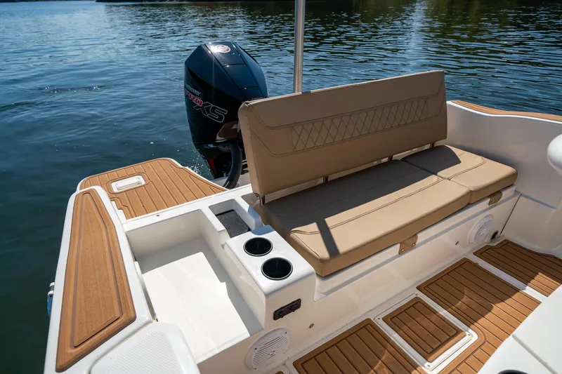 Slide: The Image of 2024 Bayliner Trophy 20CX boat interior with cushioned seating and outboard motor. - 11