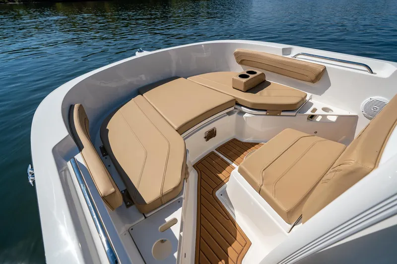 Slide: The Image of 2024 Bayliner Trophy 20CX boat interior with tan seating and wood accents on water. - 17