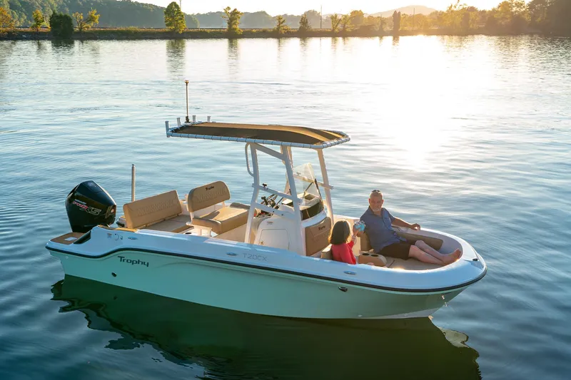 Slide: The Image of 2024 Bayliner Trophy 20CX boat on serene water at sunset, with passengers relaxing. - 2