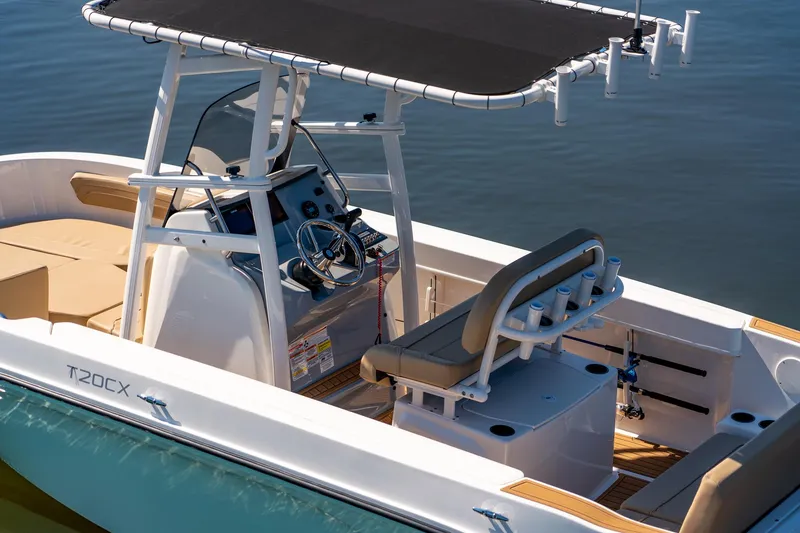 Slide: The Image of 2024 Bayliner Trophy 20CX boat interior with helm and seating, on calm water. - 26