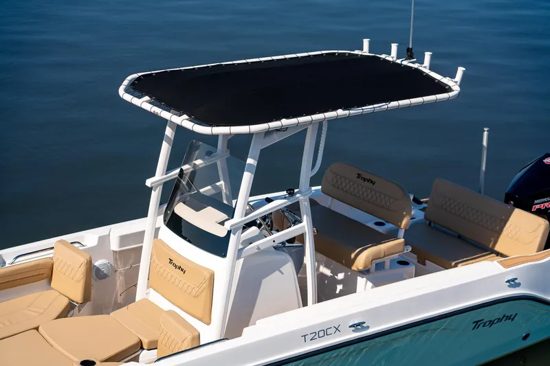 Slide: The Image of 2024 Bayliner Trophy 20CX boat with T-top and cushioned seating on calm water. - 27