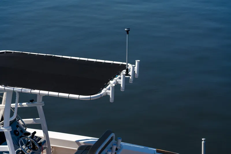 Slide: The Image of 2024 Bayliner Trophy 20CX boat with T-top and rod holders on calm water. - 29