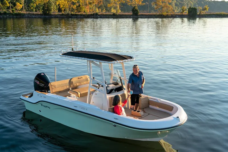 Slide: The Image of 2024 Bayliner Trophy 20CX boat on a calm lake with two people onboard. - 6